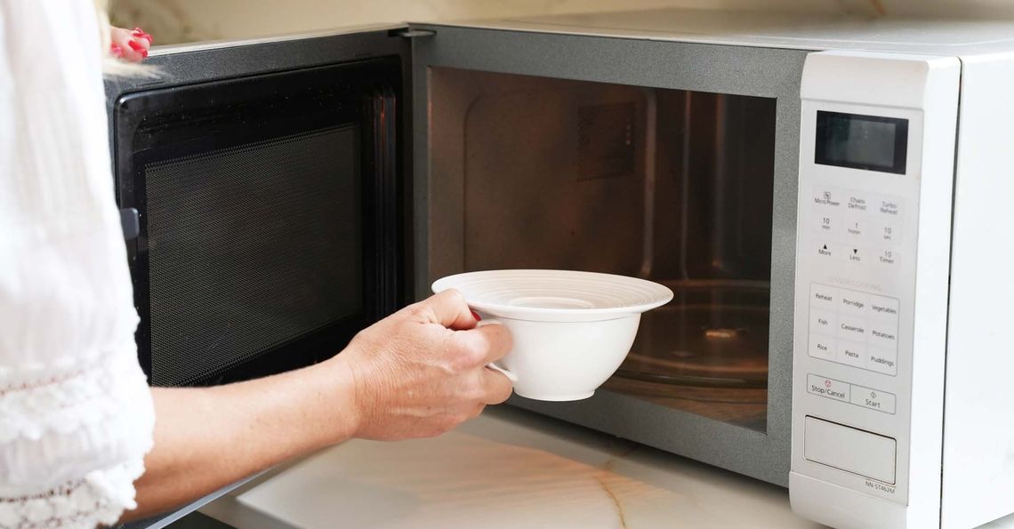 Covered egg being placed in the microwave